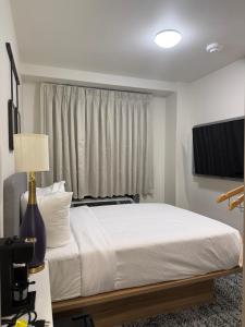 a bedroom with a white bed and a window at Sleep Inn in Brooklyn