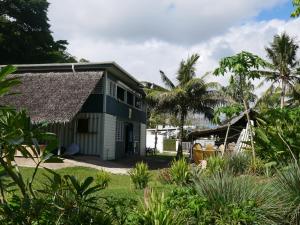 ein Haus mit Reetdach und einem Hof in der Unterkunft Vanuatu Kite & Surfing's Surf Lodge in Port Vila
