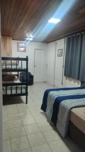 a room with two bunk beds and a couch at Pousada Central Quarto 6 in Joinville