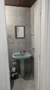 a bathroom with a green sink and a mirror at Pousada Central Quarto 6 in Joinville