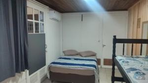 a small bedroom with a bed and a window at Pousada Central Quarto 6 in Joinville