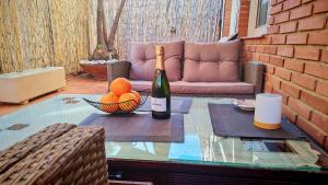 a bottle of wine and a bowl of fruit on a table at Les Arts in Valencia