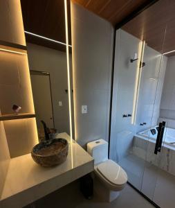 a bathroom with a sink and a toilet and a shower at Âmbar Chalés in Ametista do Sul