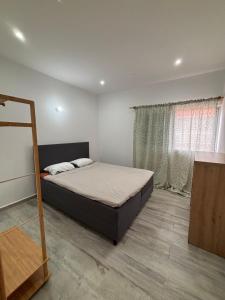a bedroom with a bed and a window at Caetana e Ferro in Calheta