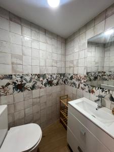 a bathroom with a toilet and a sink at Villa Marín in Aroche