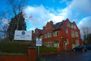 a large red building with a sign in front of it at Broadfield Park Hotel by Belvilla in Rochdale +19 photos