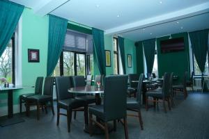 a dining room with green walls and tables and chairs at Broadfield Park Hotel by Belvilla in Rochdale
