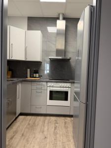 a kitchen with stainless steel appliances and white cabinets at Hansa Pension 2 Hamburg - Ruhige Zimmer mit Gemeinschaftsküche in Hamburg