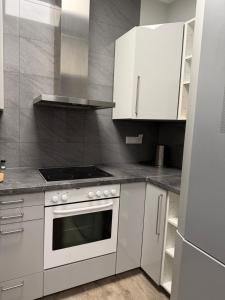 a kitchen with a stove and white cabinets at Hansa Pension 2 Hamburg - Ruhige Zimmer mit Gemeinschaftsküche in Hamburg