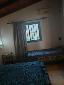 a bedroom with two beds and a window at Cabaña Quimey in Villa Rumipal