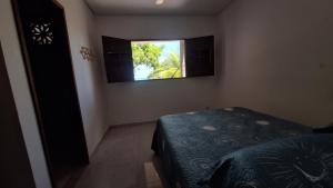 a bedroom with a bed and a window on the wall at Mirante Rota do Mar in Maceió