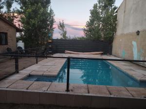 a swimming pool in a yard with a fence at Cabaña Quimey in Villa Rumipal