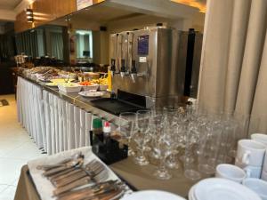 a buffet line with wine glasses and plates of food at Dalmo Hotel in Gravatal