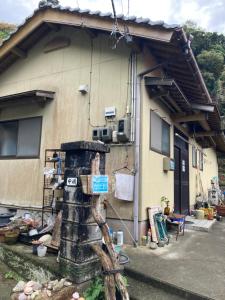 a house with a statue in front of it at 岬の民宿なにわ in Uwajima +13 photos