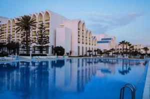 una grande piscina di fronte a un edificio di Amir Palace a Monastir