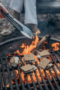 a person is cooking food on a grill at Postcard Cabins Homochitto, Outdoor Collection by Marriott Bonvoy in Meadville +28 photos