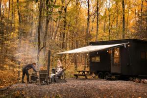 a group of people sitting at a table outside of a trailer at Postcard Cabins Hocking Hills, Outdoor Collection by Marriott Bonvoy in Nelsonville