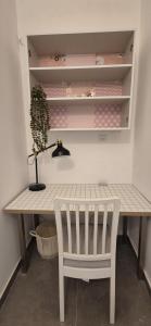 a table and a chair with a plant and a lamp at Central and stylish in Rechovot