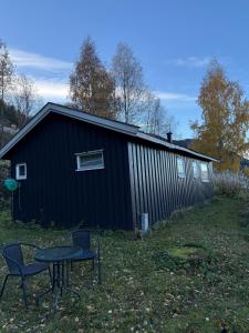 a black building with a table in front of it at Lite hus i Vestre Slidre in Vollen