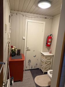 a bathroom with a door and a sink and a toilet at Lite hus i Vestre Slidre in Vollen