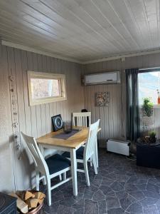 a dining room with a wooden table and chairs at Lite hus i Vestre Slidre in Vollen