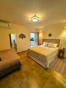 ein Schlafzimmer mit einem großen Bett und einem Fenster in der Unterkunft Manduvi in Ilhabela