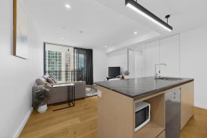 a kitchen with a counter top and a living room at Brisbane One Views Level 15 2BR Apartment in Brisbane