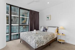 a bedroom with a bed and a large window at Brisbane One Views Level 15 2BR Apartment in Brisbane