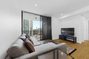 a person laying on a couch in a living room at Brisbane One Views Level 15 2BR Apartment in Brisbane