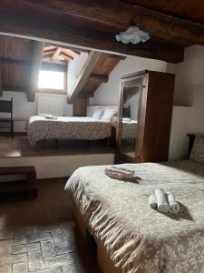 a bedroom with two beds and a mirror in it at Santocasale in Rocca di Mezzo