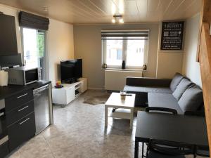 a living room with a couch and a tv at Studio AG in Mellet