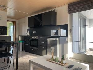 a kitchen with black cabinets and a white table at Studio AG in Mellet