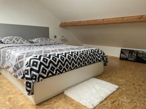 a bedroom with a bed with a black and white comforter at Studio AG in Mellet
