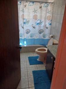 a bathroom with a toilet and a shower curtain at LRM Home in Basseterre