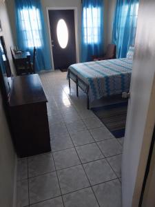 a bedroom with a bed and a table and a chair at LRM Home in Basseterre +3 photos