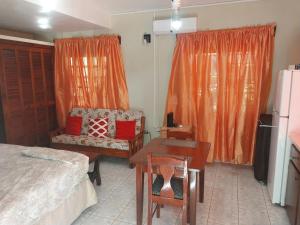 a bedroom with a bed and a desk and a table at LRM Home in Basseterre