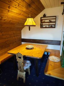 a wooden table in a room with a bench and a lamp at Nassfeld Sonnleitn by Semi in Hermagor