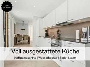 a kitchen with white cabinets and a living room at Ferienhausträume - ebenerdiges Bodensee Apartment mit Garten und großer Terrasse mit Grill in Kreuzlingen