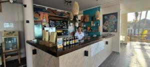 a woman standing behind a bar in a restaurant at Hotel Punta del Mar in Máncora Chico
