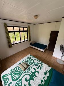 a bedroom with a bed and a window at TIKI LODGE Hiva oa in Atuona