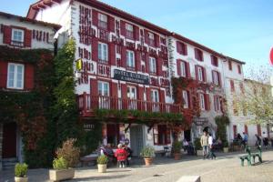 a large red and white building with people sitting outside at ZEcamping 4 animaux acceptés hammam sauna piscine et soirées animées in Espelette +1 photo