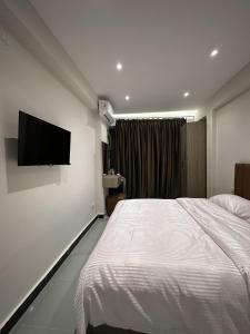 a bedroom with a bed and a flat screen tv at Atlantis pirámides view Inn in Cairo