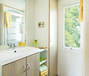 a bathroom with a sink and a mirror and a window at ZEcamping 3 étoiles - bord de Loire - proximité directe des châteaux in Sully-sur-Loire