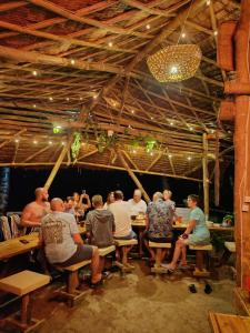 a group of people sitting at tables in a restaurant at Kamp Tapik - Sibaltan in El Nido