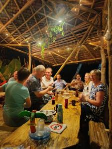 a group of people sitting around a wooden table at Kamp Tapik - Sibaltan in El Nido +44 photos