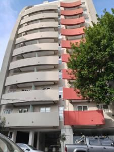 an apartment building with red balconies in a parking lot at Monoambiente Premium in La Plata