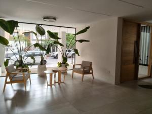 a living room with chairs and tables and plants at Monoambiente Premium in La Plata