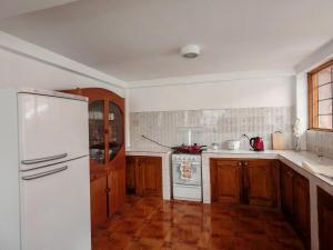 a kitchen with a white refrigerator and wooden cabinets at UMAY lodge house in Urubamba +16 photos