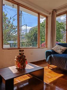 a living room with a couch and a table and windows at UMAY lodge house in Urubamba