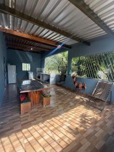 a large patio with a table and chairs on a wooden floor at Recanto do 7 in Presidente Figueiredo